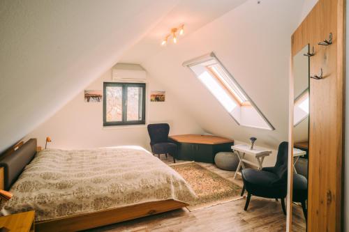 a bedroom with a bed and a desk and two chairs at Éliás Borbirtok in Badacsonytomaj