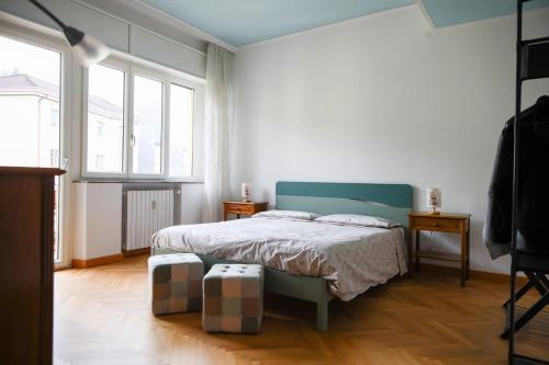 a bedroom with a bed and two windows at Casa Gabry - your first step in the Dolomites in Belluno
