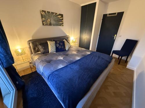 a bedroom with a bed with a blue comforter at Blue Haven Sèvres in Sèvres