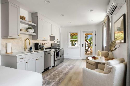 a kitchen with white cabinets and a living room at The Sumter 1bd Condo 1 Block to Ocean in Folly Beach