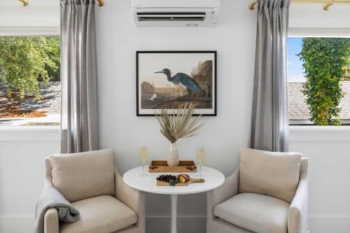 a living room with two chairs and a table and two windows at The Sumter 1bd Condo 1 Block to Ocean in Folly Beach