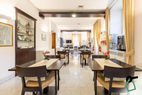 a restaurant with tables and chairs and a kitchen at Hotiday Cagliari Lungomare in Cagliari