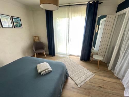 a bedroom with a blue bed and a large window at La Chambre Bleue in Quimper