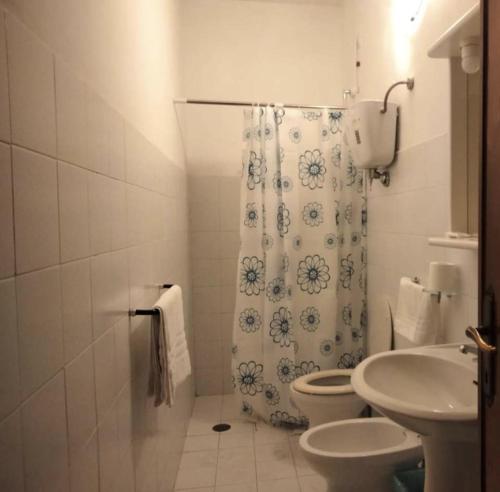 a bathroom with a toilet and a shower curtain at Albergo Il Pescatore in Trevi