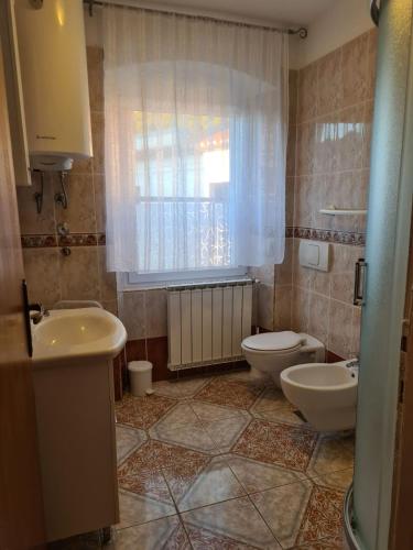 a bathroom with two toilets and a sink and a window at Apartmani Viola in Momjan