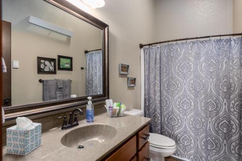 a bathroom with a sink and a toilet and a mirror at Pineview Cabin Retreat in the Black Hills- 4 bed, 2 bath in Sturgis