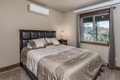 a bedroom with a large bed and a window at Pineview Cabin Retreat in the Black Hills- 4 bed, 2 bath in Sturgis