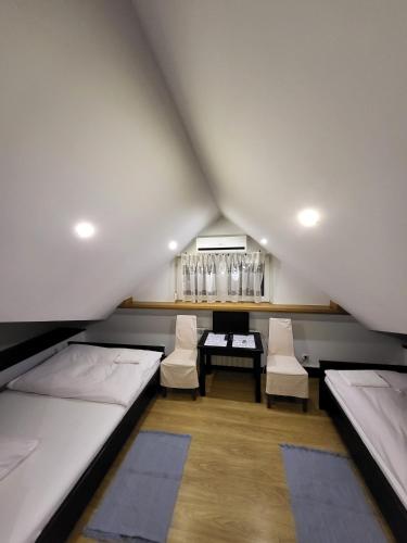 a room with two beds and a table and chairs at Kryształowa poddasze in Józefów