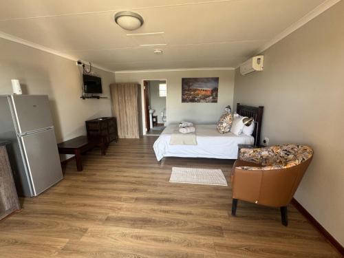 a bedroom with a bed and a couch in it at Lake Grappa Guestfarm in Augrabies
