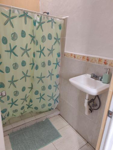 a bathroom with a shower curtain and a sink at Casa Ixtapa in Ixtapa