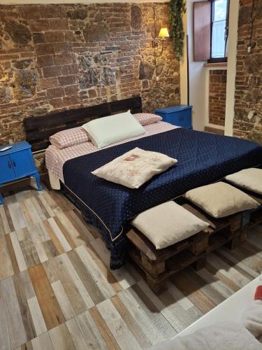 a bedroom with a bed and a brick wall at IL Vicoletto in Serra San Bruno