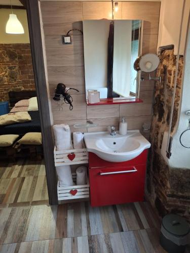 a bathroom with a sink and a mirror and a bed at IL Vicoletto in Serra San Bruno