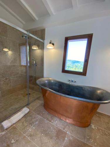 a large wooden tub in a bathroom with a window at Maison Tropez in Cogolin