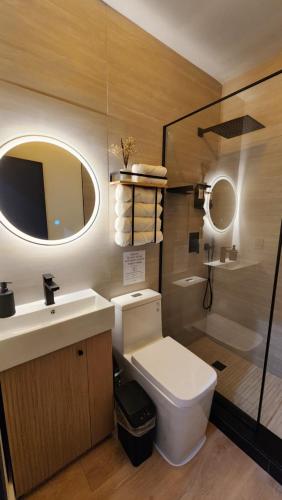 a bathroom with a toilet and a sink and a mirror at Pop Art Loft in Hialeah