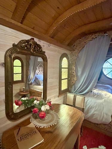 a bedroom with a table and a mirror and a bed at La roulotte du petit paradis in Saint-Rémy-de-Provence