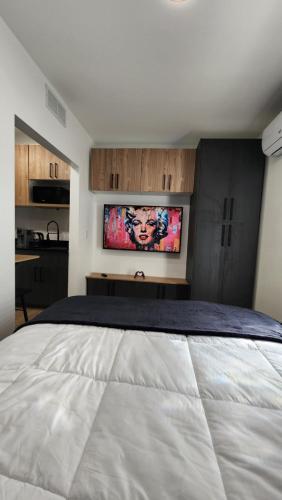 a bedroom with a large bed with a tv on the wall at Pop Art Loft in Hialeah
