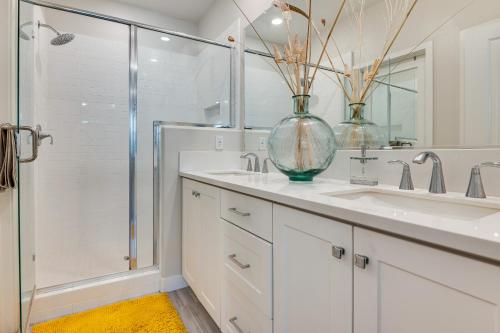a bathroom with two sinks and a glass vase on the counter at 12 Mi to DTLA! Multi-Level Charmer w/ Pool Access in Montebello