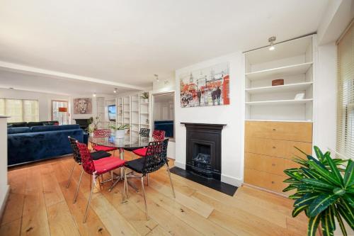 a living room with a table and chairs and a fireplace at SoHo Elegant Apartment - West End 102 sq meters in London
