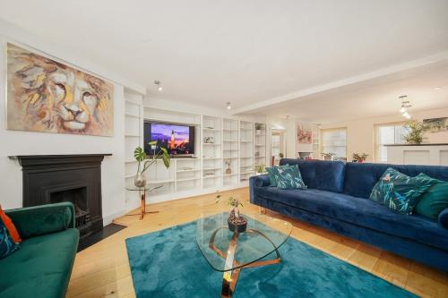 a living room with a blue couch and a fireplace at SoHo Elegant Apartment - West End 102 sq meters in London