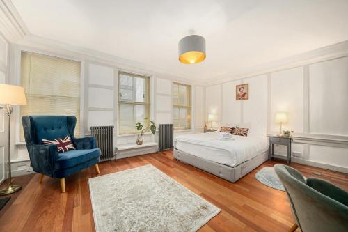 a bedroom with a bed and a blue chair at SoHo Elegant Apartment - West End 102 sq meters in London