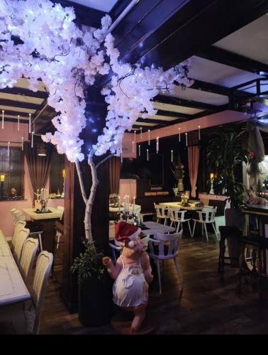 a teddy bear standing next to a tree in a restaurant at Gästezimmer vom Restaurant Saustall in Mestlin