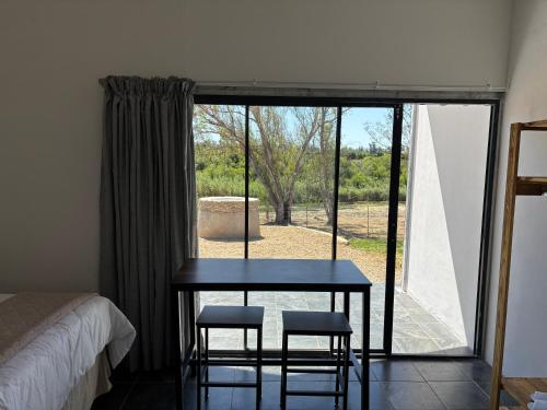 ein Tisch und zwei Stühle in einem Zimmer mit Fenster in der Unterkunft Riverview Rest in Addo