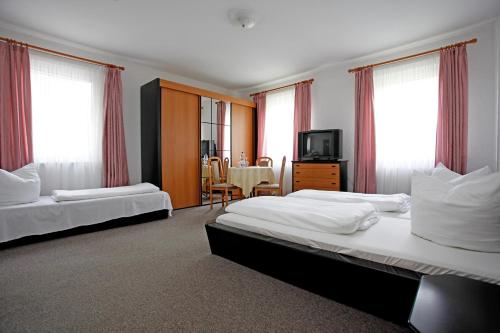 a hotel room with two beds and a tv at Hotel Heidenschanze in Dresden