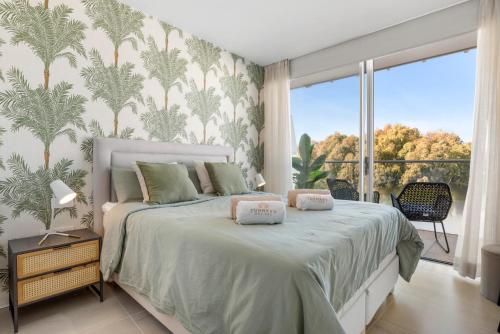 a bedroom with a bed and a large window at Casa Costa Tropical in Estepona