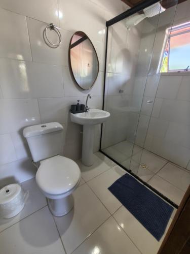 a bathroom with a toilet and a sink and a mirror at Oka do Mar Hospedaria - Suíte com varanda na Ilha do Mel - Nova Brasília in Ilha do Mel