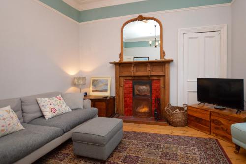 a living room with a couch and a fireplace at Montford Shore in Rothesay