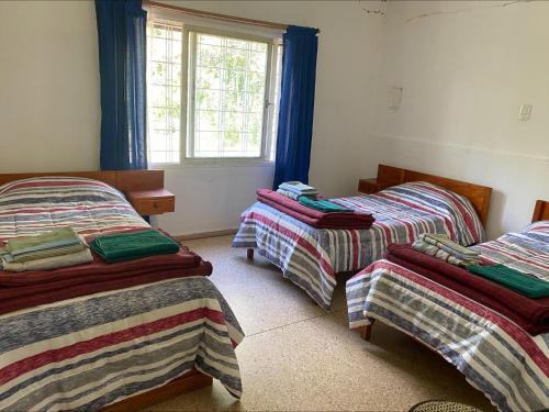 a room with two beds and a window at Casa los Churumbeles in Potrerillos