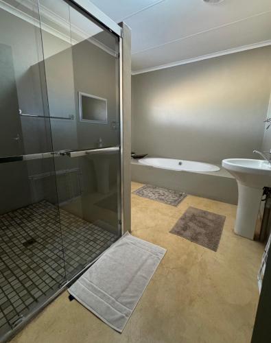 a bathroom with a shower and a sink and a toilet at Lake Grappa Guestfarm in Augrabies