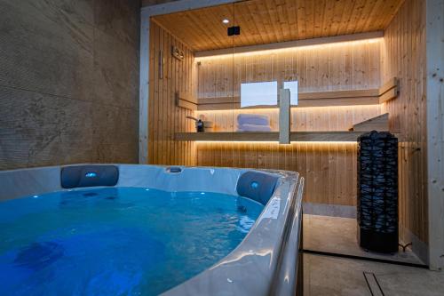 a large tub in a bathroom with wooden walls at Góralska Dolina II Jacuzzi & Sauna in Zakopane