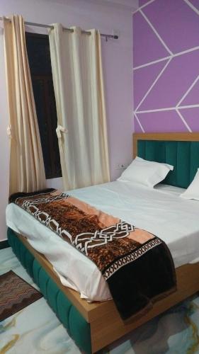 a bedroom with two beds and a window at Hotel Dharma palace in Prayagraj