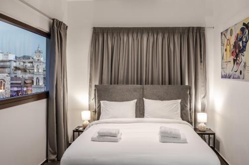 a bedroom with a large bed with two towels on it at Ermou Residences in Volos