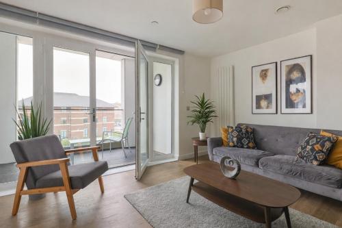 a living room with a couch and a table at 2-Bedroom Modern apt with Gym, roof terrace, Free Parking and 3 min walk to train st in Hersham