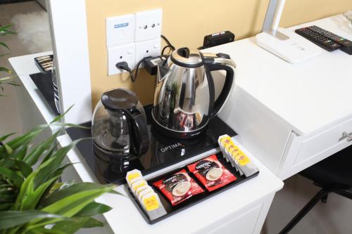 a tea kettle on a desk with a tray of food at Ayaana Boutique Hotel in Kandy