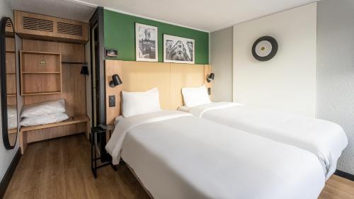 a room with two beds and a closet at Campanile Brest - Gouesnou Aeroport in Gouesnou