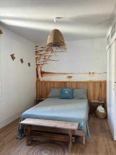 a bedroom with a bed with a bench on it at Andernos les pieds dans l eau in Andernos-les-Bains