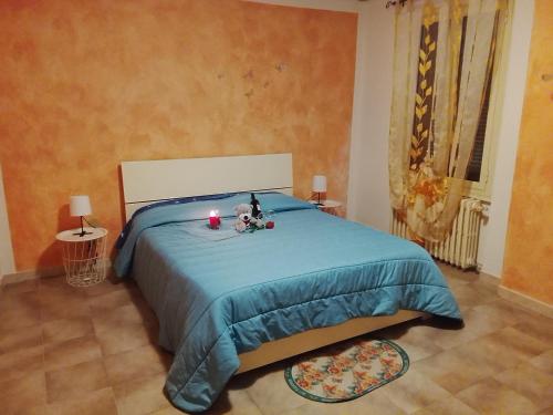 a bedroom with a bed with a blue blanket and candles at Casa Alice in Ciriè