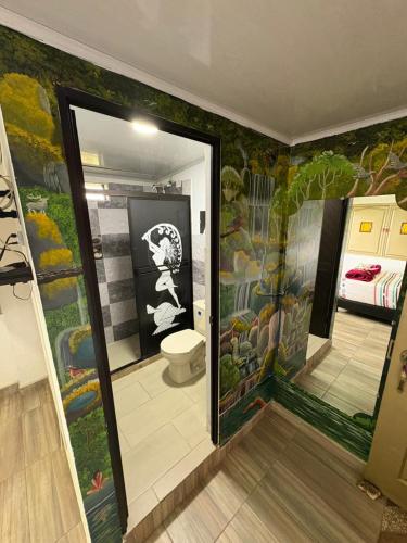 a bathroom with a toilet with a painting on the wall at Rancho Akila in Filandia
