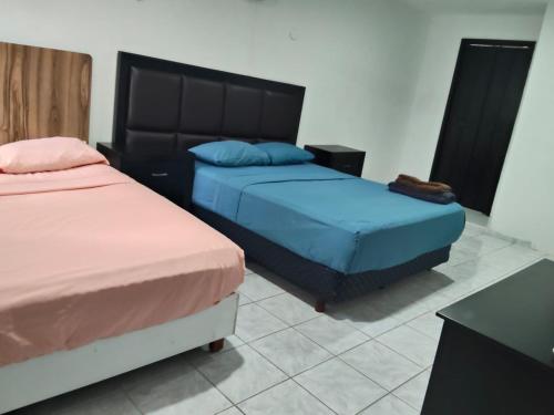 a bedroom with two beds and a table at Casa pame 2026 in Mérida