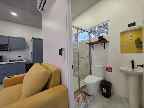 a bathroom with a couch and a toilet and a sink at Sunshine at Life's a Beach in Uvita