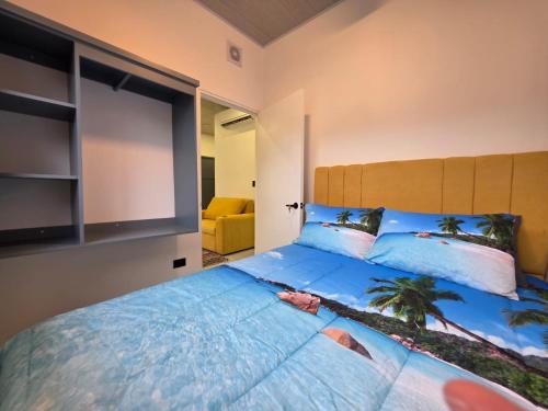 a bedroom with a large bed with blue pillows at Sunshine at Life's a Beach in Uvita