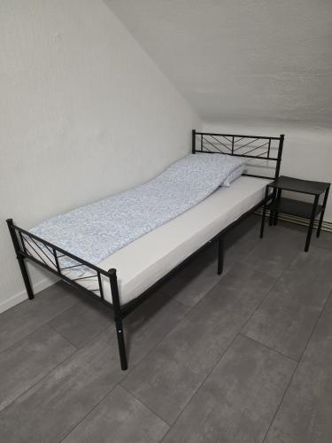 a bed in a room with a black frame at modernes & einfaches übernachten in Bruchsal