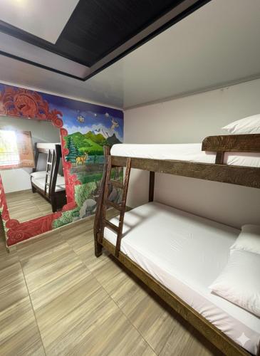 a room with two bunk beds and a mural at Rancho Akila in Filandia