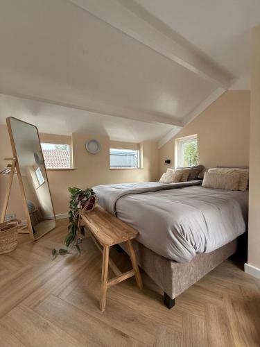 a bedroom with a large bed and a wooden floor at BLUSH Bed and Breakfast in Sprundel