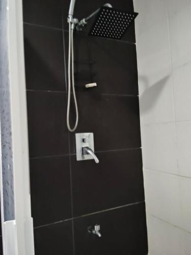 a bathroom with a shower with black tiles at Casa pame 2026 in Mérida