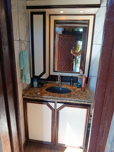 a bathroom with a sink and a mirror at Casa da Lagoa perto do Mar in Pescaria Brava