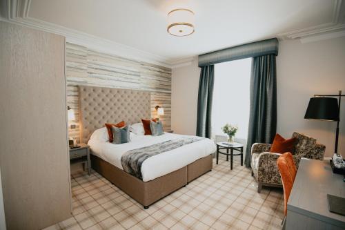 a hotel room with a large bed and a chair at The Seafield Arms-Cullen in Cullen